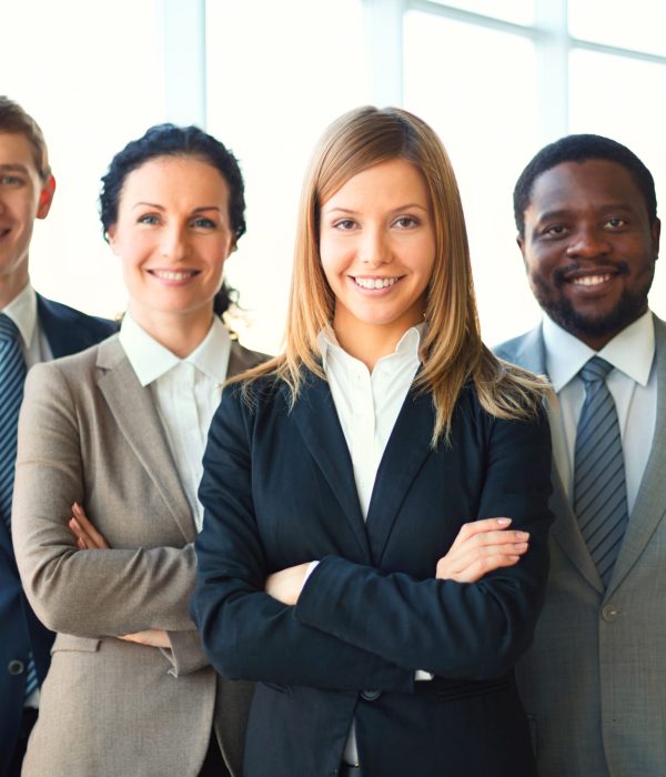 Group of business partners looking at camera with smiles, pretty leader in front